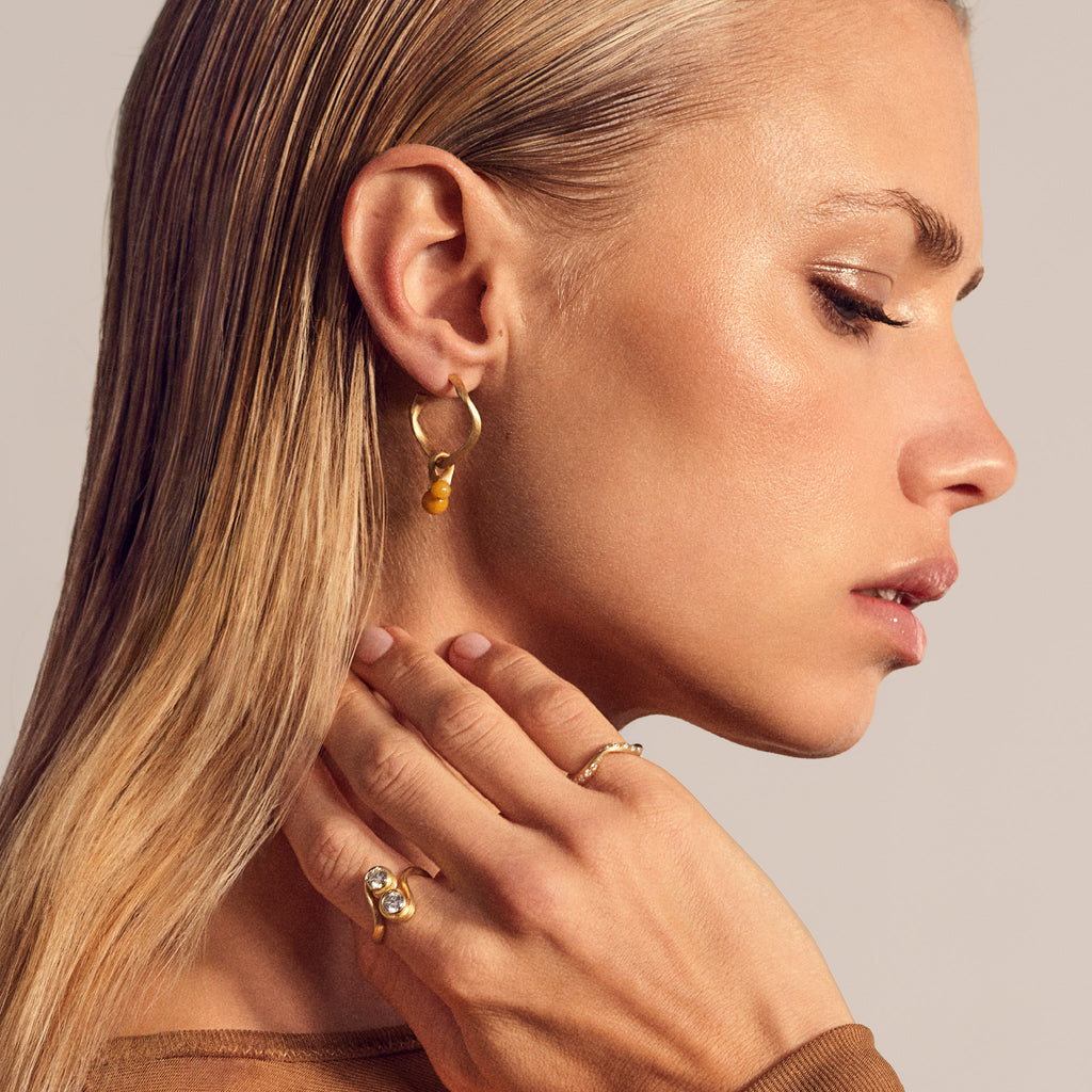 Vega Creol øreringe, lille i guld 18 K. Vist med Vega vedhæng med gul aventurin. Dulong Fine Jewelry